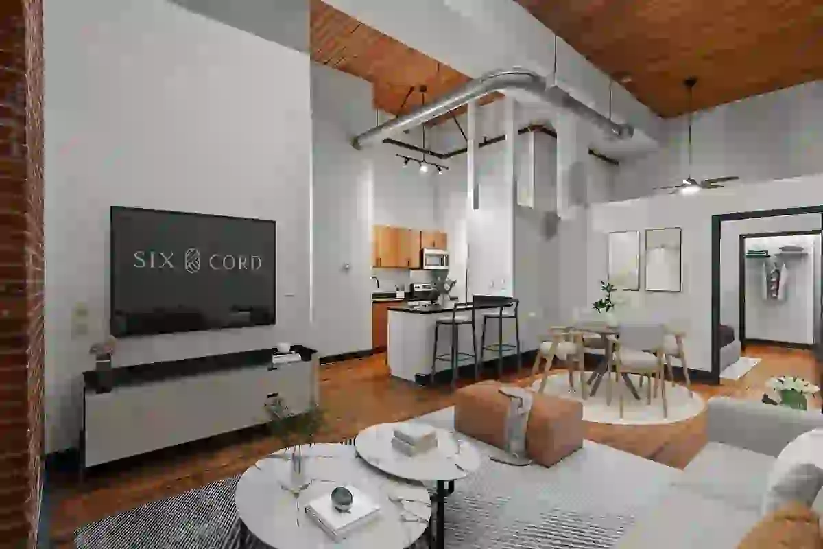 Living room in Six Cord Apartments with tall ceilings featuring slatted wood ceilings and urban-style exposed ducts