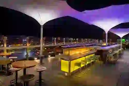 Nightime rooftop bar scene with St. Louis cityscape in the background at Rooftop 360