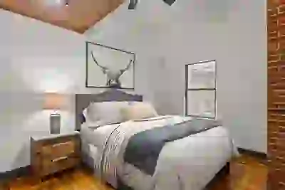 Bedroom at Six Cord Apartments with hardwood floors beneath a large bed