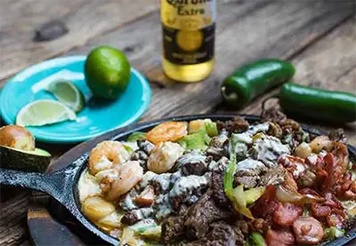 Close-up of Mexican food with lime, jalepno, and beer in background at Rosalita's Cantina