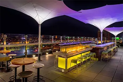 Nightime rooftop bar scene with St. Louis cityscape in the background at Rooftop 360