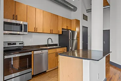 Lage, open kitchen with island and wood cabinetry, dark quartz countertops